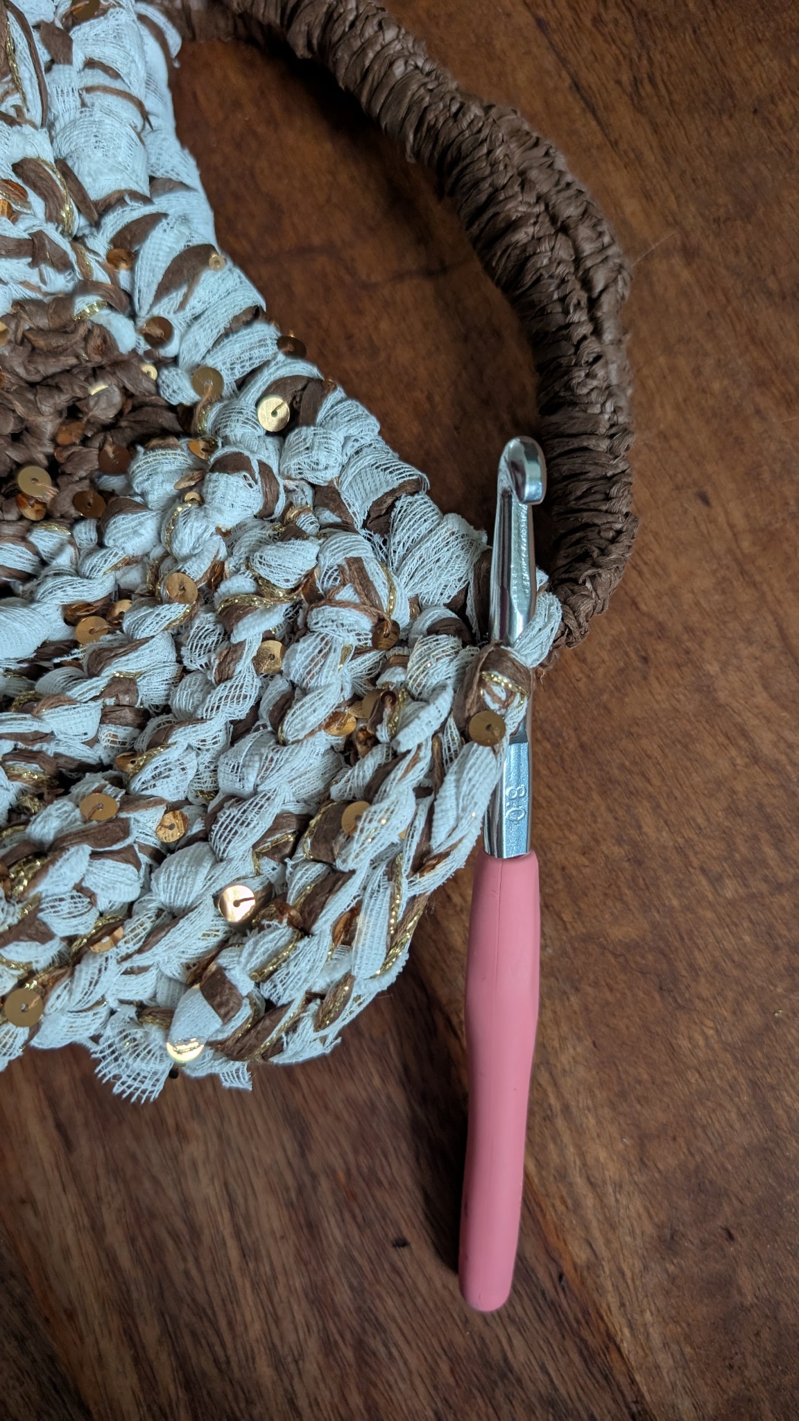 Original close-up of the crochet hook beside the textured bag and wrapped handle