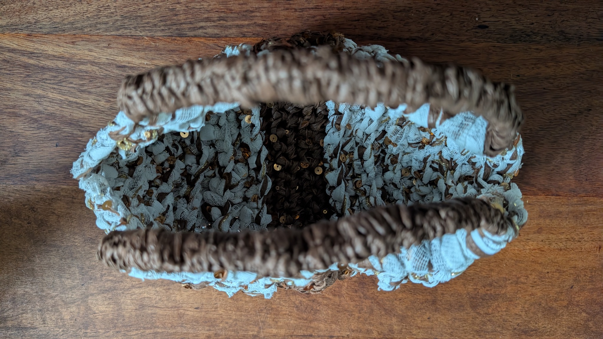 View into the finished net-curtain handbag, showing its opening and wrapped handles