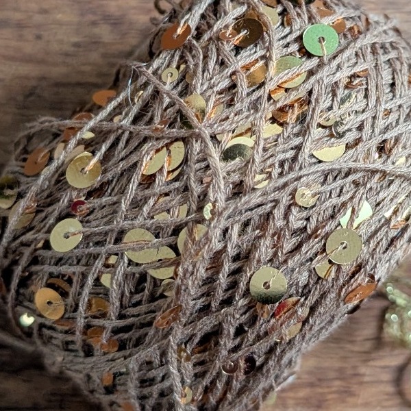 Close-up of yarn threaded with golden sequins