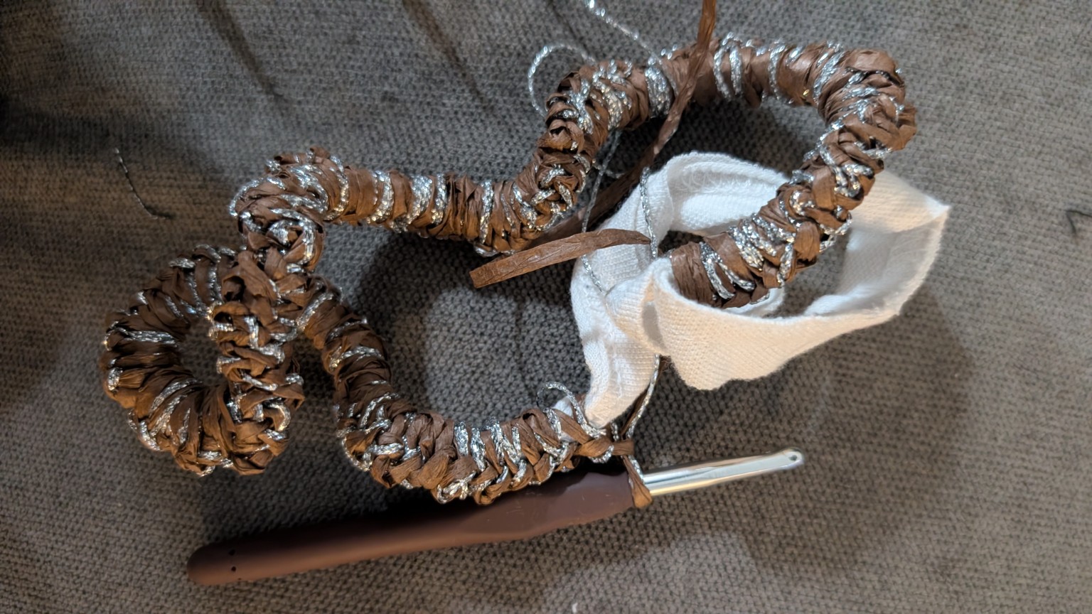 The PE-shirt cut-offs alongside the handles as they are wrapped with brown raffia and silver yarn