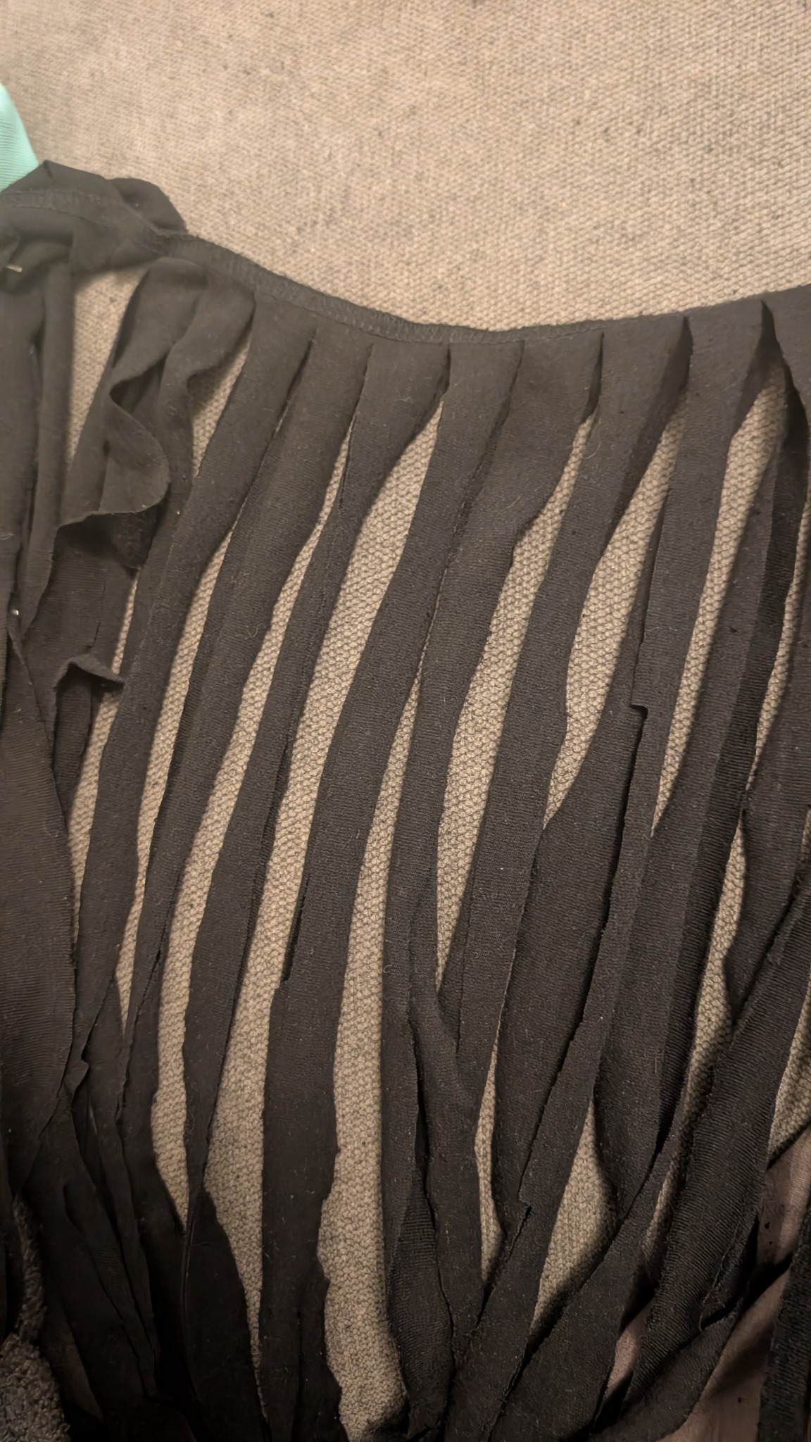 Black clothing cut into long strips ready for making