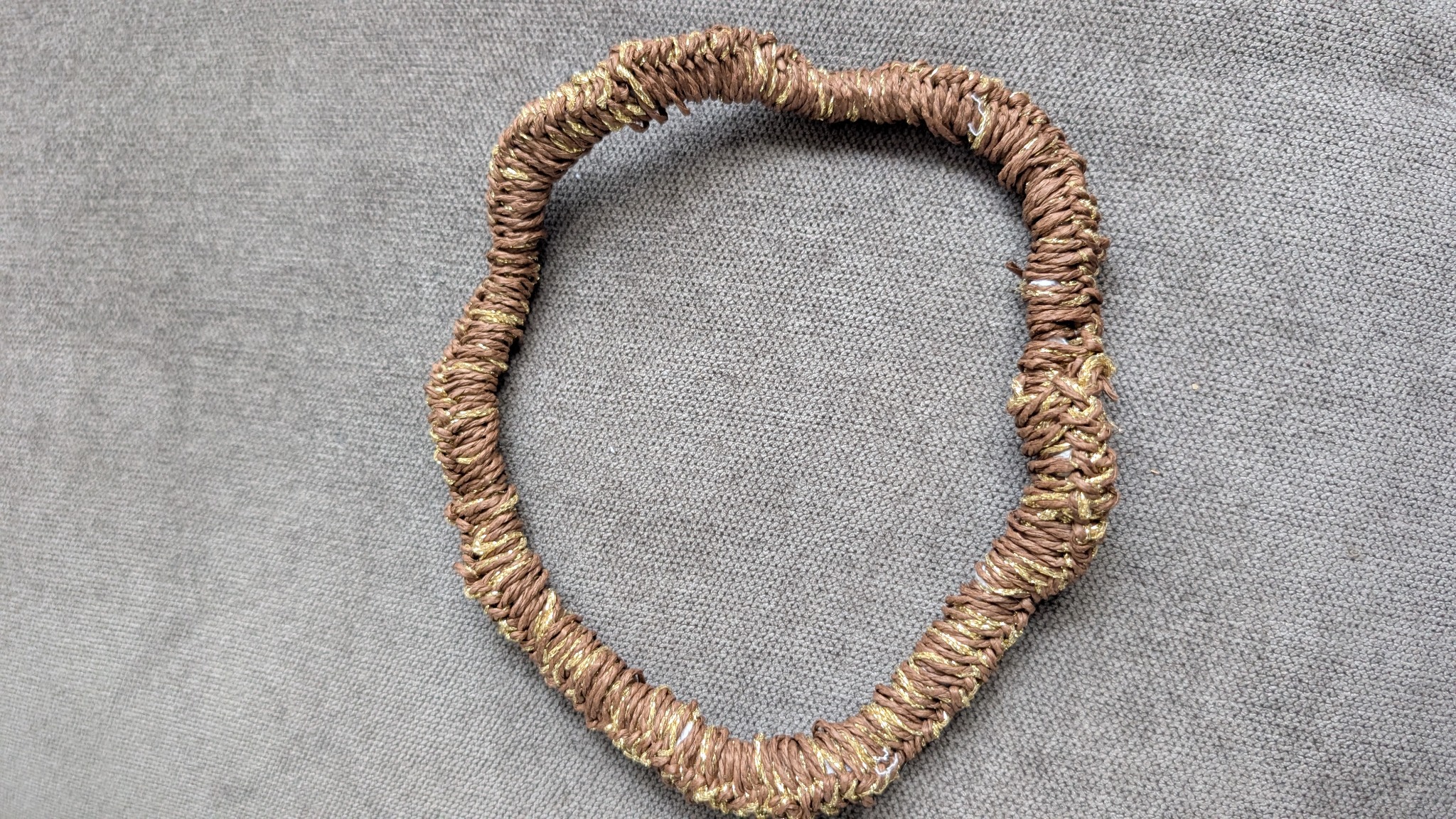 The handmade bag handle wrapped in raffia and metallic yarn