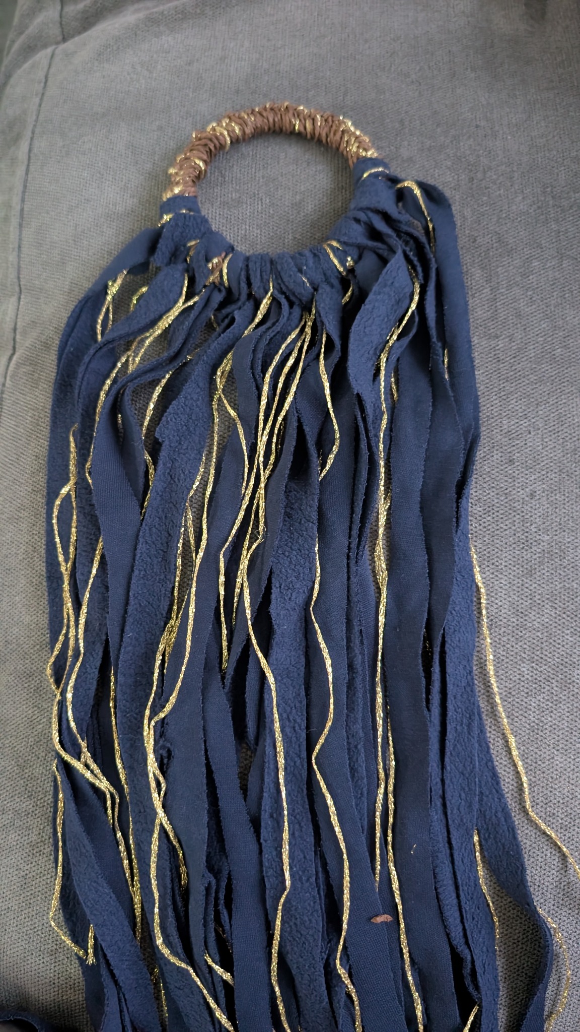 Navy textile strips and metallic thread arranged around the handle